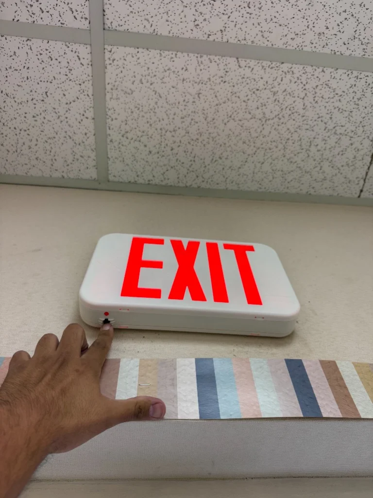 Push-button testing of LED emergency exit light sign at music hall in Albuquerque NM